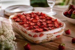 Erdbeer-Tiramisu ohne Gelatine in einer Auflaufform, geschichtet mit frischen Erdbeeren, Löffelbiskuits und einer cremigen Mascarpone-Quark-Creme, garniert mit Erdbeerscheiben