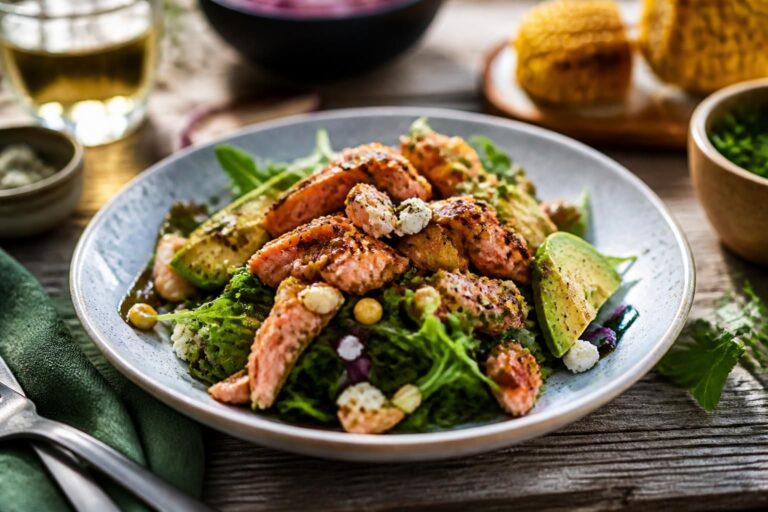 BBQ-Lachssalat mit gegrilltem Lachsfilet, knackigem Gemüse und Honig-Senf-Dressing auf einem weißen Teller