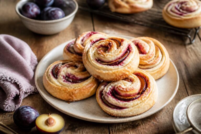 Pflaumen-Quark-Schnecken ohne Hefe auf einem Backblech, goldbraun gebacken mit saftiger Pflaumenfüllung und Zimtzucker, von oben fotografiert